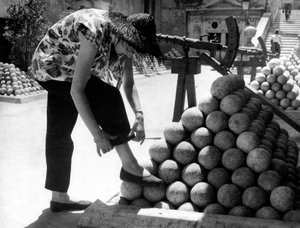 Una donna aggiusta il polsino dei pantaloni mentre appoggia il piede su una pila di palle di cannone all