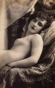 Una giovane donna che posa nuda su un divano