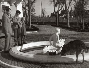 Gino Bartali con due bambini e un cane vicino a una fontana da Unknown photographer