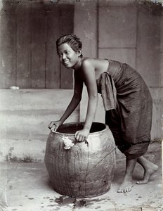 Giovane donna thailandese sorridente, spingendo un grande contenitore da Unknown photographer