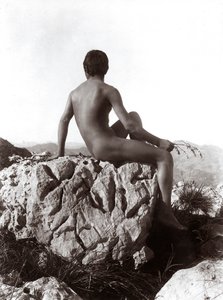 Giovane uomo che posa su una roccia
