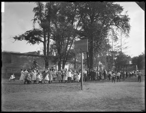 Ragazzi e ragazze che giocano a tiro alla fune in un parco giochi non identificato, c.1910