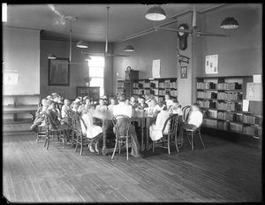 Bambini ascoltano una donna nella sala di lettura di una filiale non identificata della Queens Borough Public Library
