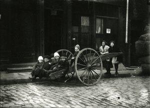 Gruppo di bambini in carrozza, con ragazza e donna in piedi dietro, c.1910-21