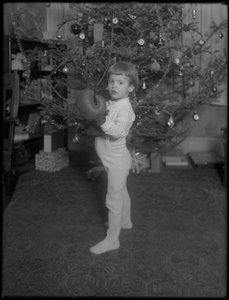 Bambino non identificato davanti a un albero di Natale con guantoni da boxe, 1915-16