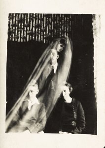 Fenomeno paranormale: ritratto di una donna e due uomini, e lo spirito di una donna che appare dietro di loro, verso 1920