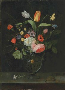 Rose, tulipani, un narciso e altri fiori in un vaso di vetro, su un ripiano di pietra con un topo