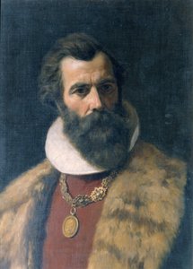 Uomo barbuto con colletto di pelliccia e catena