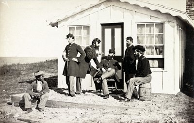 Cinque soldati della Guerra Civile riuniti su un portico di terra fuori casa, giovane afroamericano seduto vicino a loro, 1861-65 da American Photographer