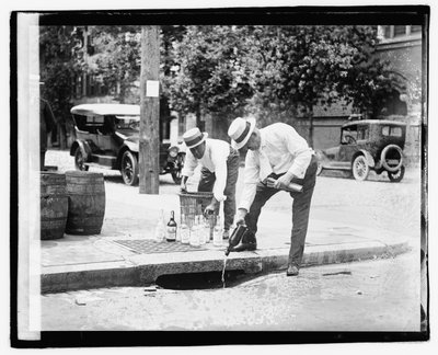 Due uomini che versano liquore in un tombino, 8 luglio 1921 (foto in bianco e nero) da American Photographer
