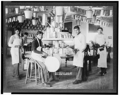Giovani nativi americani in officina di lavorazione dei metalli con secchi, vasche da bagno, annaffiatoi e altri oggetti metallici, Carlisle Indian School, Pennsylvania, c.1904 (foto in b/n) da American Photographer