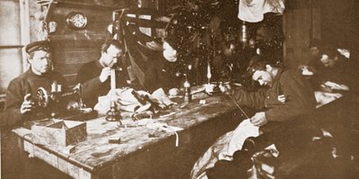 Nella capanna durante il pieno inverno, gli uomini impegnati a cucire pellicce per abiti da usare nelle slitte primaverili, pub. Londra 1907 (foto b/n) da Anthony Fiala