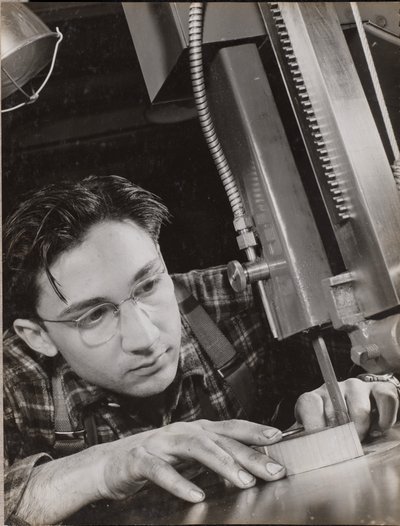 [Uomo con occhiali lavora intensamente con una lima industriale] da Arnold Eagle