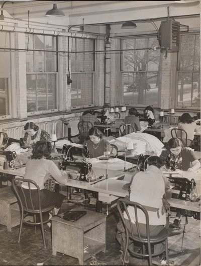 [Donne sedute alle scrivanie lavorano alle macchine da cucire] da Arnold Eagle