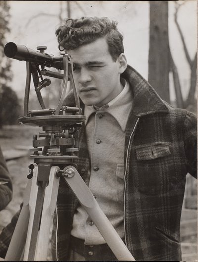 [Giovane uomo scruta attraverso un attrezzo da geometra] da Arnold Eagle