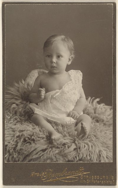 [Bambino non identificato seduto su un tappeto di pelle d