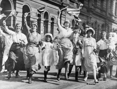 Un gruppo di donne e bambini che gioiscono in una strada di Sydney alla firma dell