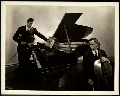 Donna cieca, Miss Harding, al pianoforte che istruisce due uomini ciechi al violino e al violoncello, 1936 da Byron Company