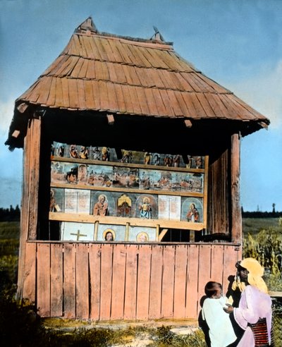 Romania, Bucovina, madre con bambino davanti a una piccola cappella con immagini dei Santi, circa 1920 da Carl Simon