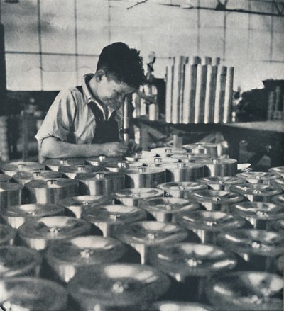 Apprendista con microscopio che testa la durezza dei pistoni, 1941 da Cecil Beaton