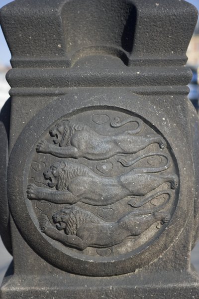 Tre leoni scolpiti in una colonna di pietra nella Piazza del Municipio da Danish School