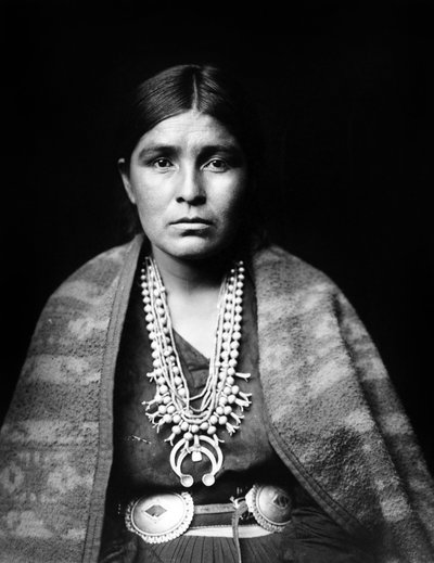Donna Navajo con collana di fiori di zucca in argento, cintura con concho, coperta sulle spalle, c. 1904, foto di Edward S. Curtis da Edward Sheriff Curtis