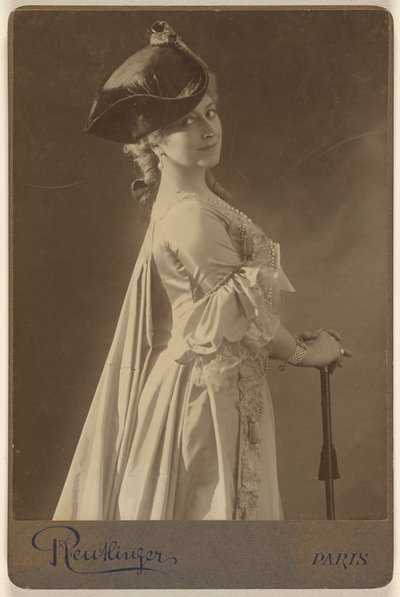 [Donna non identificata che indossa un cappello scuro, in piedi, con le mani appoggiate su un bastone da passeggio]. da Emile Auguste Reutlinger