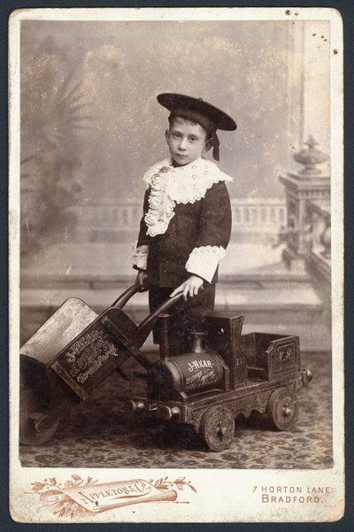 Ragazzo con un trenino giocattolo e una carriola da English Photographer