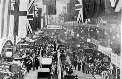 Veduta generale delle folle che ispezionano gli espositori a una mostra di motori da English Photographer