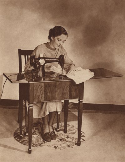 Casalinga al lavoro sulla macchina da cucire, metà anni 