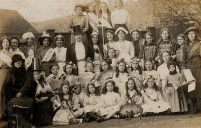 Ritratto di un gruppo di scolarette con i loro insegnanti vestiti con costumi del mondo da English Photographer