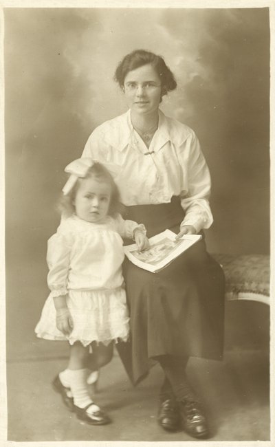 Bella ragazza, madre o governante, che mostra foto a un bambino piccolo da English Photographer