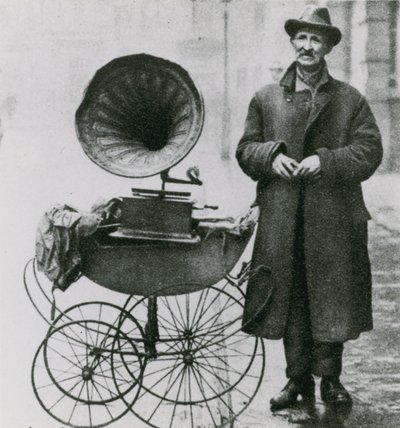 Fotografia senza titolo di un uomo con un fonografo in una carrozzina da English Photographer