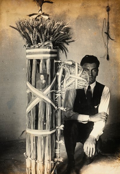 Antonio Floridi che posa vicino a fasci di littori fatti di spighe di grano. Fattoria di proprietà di Camillo Frizzoni, a Morengo, provincia di Bergamo. In cima ai fasci c