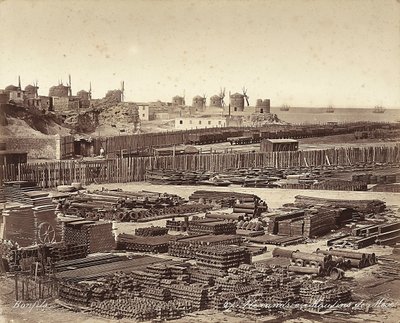 Cortile per materiali da costruzione, mulini a vento sullo sfondo, ad Alessandria, Egitto da Félix Bonfils