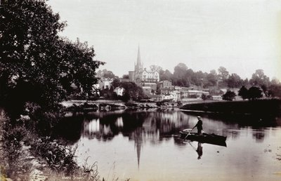 La città di Ross-On-Wye, vista da una riva del fiume. In primo piano un uomo in piedi su una barca a remi da Francis Frith