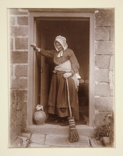 Una vecchia con una bottiglia di lievito alla porta di un cottage da Frank Meadow Sutcliffe