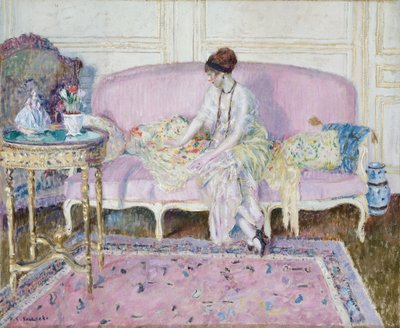 Donna seduta su un divano in un interno da Frederick Carl Frieseke