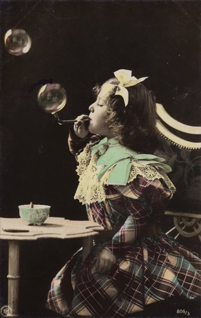 Una bambina che soffia bolle da una pipa da French Photographer