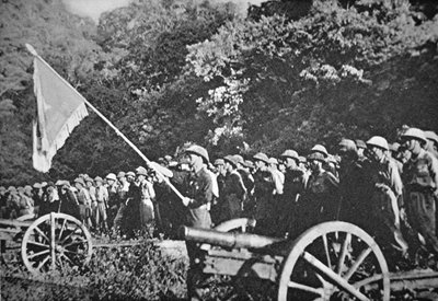 Truppe comuniste Viet Minh in parata con artiglieria leggera da campo, durante l