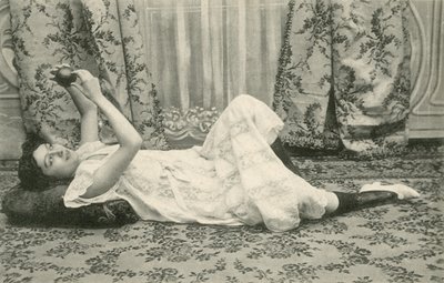 Ragazza sdraiata sul pavimento, che tiene una palla sopra la testa da French Photographer
