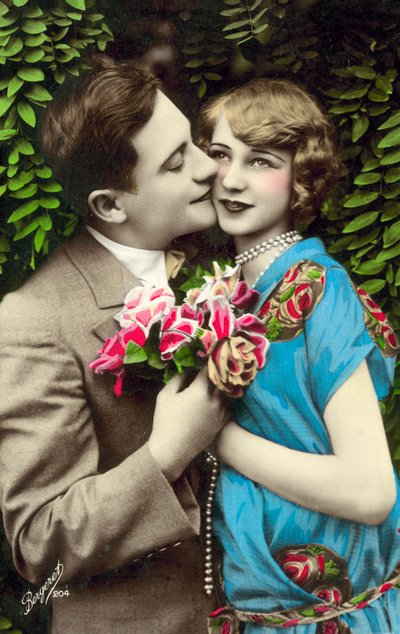 Uomo che porta fiori bacia una bella ragazza sulla guancia da French Photographer