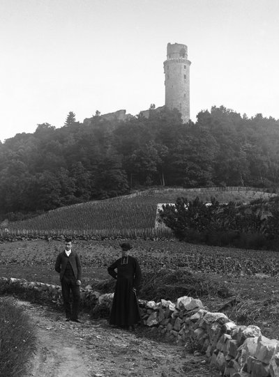 Il curato di campagna, accompagnato da un giovane, posa sulla strada davanti alla torre di Montlhery in Essone. Fotografia fine XIX secolo. Collezione Ducos. da French Photographer