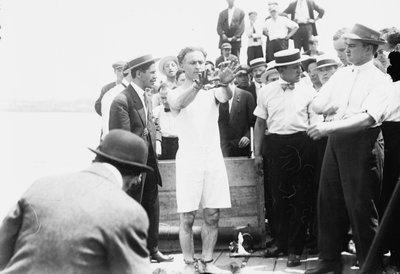 Harry Houdini ammanettato prima di essere chiuso in una cassa e calato nella baia di New York, 1912 da George Grantham Bain