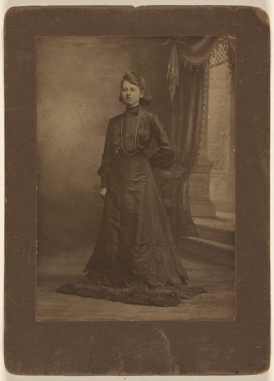 [Ritratto di una giovane donna in abito nero lungo, in piedi]. da George W. Killian