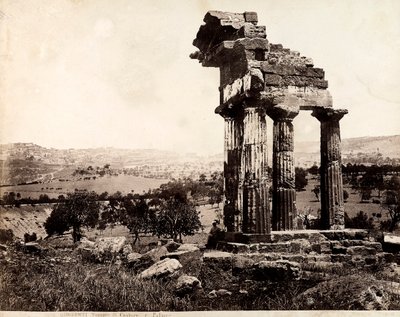 Vista delle quattro colonne rimanenti che sostengono un architrave del Tempio di Castore e Polluce nella Valle dei Templi, Agrigento. Un panorama della città è visibile sullo sfondo da Giorgio Sommer