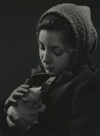 Ragazza che tiene in braccio un gattino bianco. Primi anni 