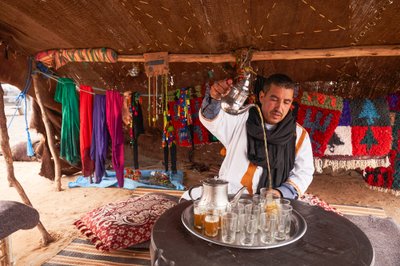 Un locale che serve tè alla menta a Erg Chebbi nel deserto vicino a Merzouga, Marocco, 2019 da Ira Block