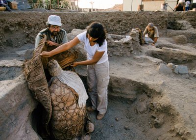 Archeologi con un fagotto di mummia trovato nel sito di scavo della scuola, 2001 (foto) da Ira Block
