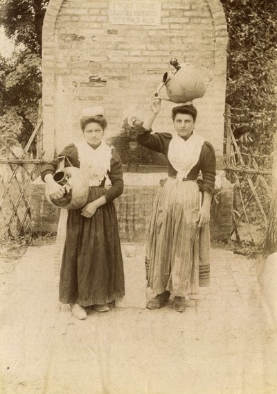 Due giovani donne che indossano abiti tradizionali e trasportano giare di terracotta vicino a un pozzo, Marche, Italia, 1910 ca. da Italian Photographer
